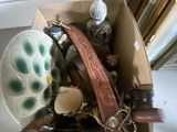 une boîte remplie d'objets hétéroclites posée sur le sol
