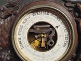 a clock with a barometer in the middle of it