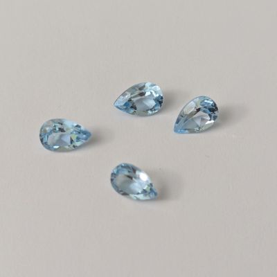 trois pierres précieuses de topaze bleue sur un fond blanc