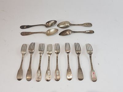 many forks and spoons laid out on the table