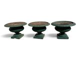 trois vases verts empilés les uns sur les autres sur une surface blanche