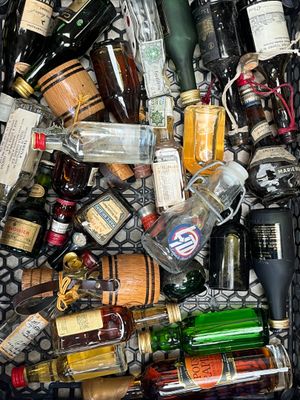 de nombreuses bouteilles d'alcool dans un panier posé par terre