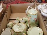 a box full of tea cups and saucers on the floor