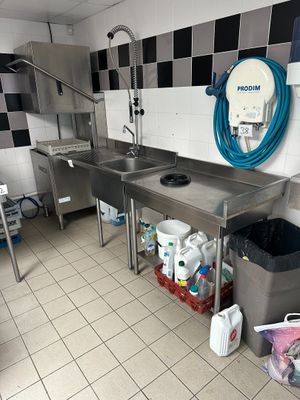 a kitchen with a sink and a lot of trash on the floor
