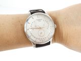 a person that is holding a watch on their arm