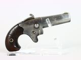 un vieux pistolet avec une crosse en bois, posé sur un socle transparent