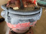 a red and black vacuum sitting on the floor