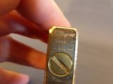 someone is holding a gold bar in their hand on a table