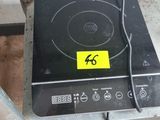 une plaque de cuisson noire sur laquelle est collé un autocollant jaune