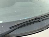 un chat assis sur le pare-brise d'une voiture