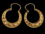 une paire de boucles d'oreilles en or sur fond noir