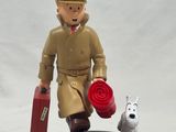 a figurine of a man with a suitcase and a dog