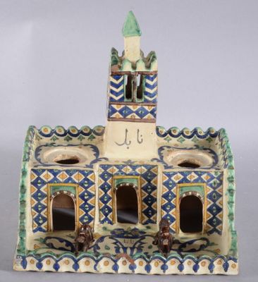 une figurine en céramique représentant un bâtiment avec une tour horloge