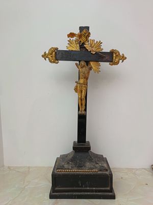 a statue of jesus on a cross on a marble table