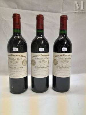 three bottles of red wine are lined up on a table