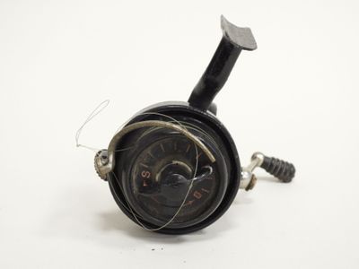 a close up of a black clock on a white surface