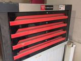 une boîte à outils rouge et noire posée sur un radiateur