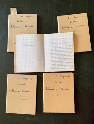 four open notebooks sitting on top of a table with writing on them