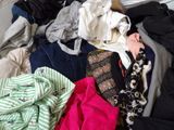a pile of clothes on a bed in a room