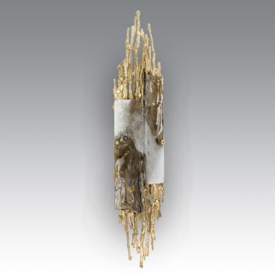 une sculpture en or et en argent représentant un visage sur lequel figure un autre visage