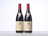two bottles of red wine sitting next to each other on a table
