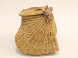 woven wicker purse with wooden handle on white background