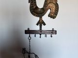 a metal rooster on top of a wooden stand