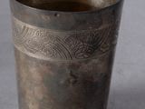 une vieille coupe en argent posée sur une table, à côté d'une banane