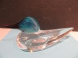 un canard en verre posé sur une table
