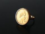 a close up of a gold coin ring on a black surface