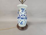 a blue and white vase with a lamp on it
