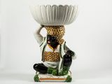 une figurine représentant un homme tenant un bol sur la tête
