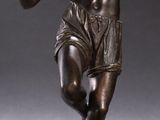 statue of a man holding a tennis racquet in his right hand