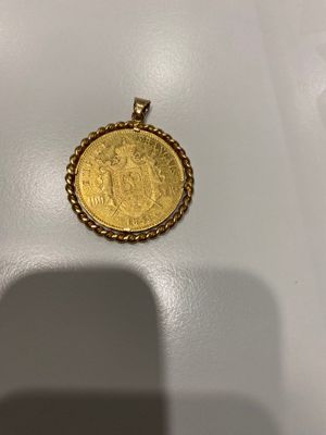 Une pièce d'or est représentée sur une surface blanche
