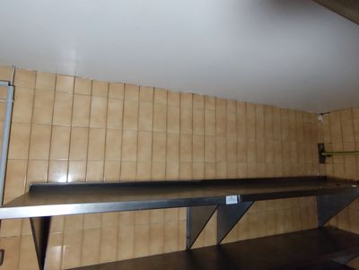 une étagère métallique au milieu d'un mur carrelé