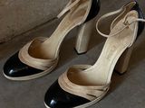 pair of black and white high heeled shoes sitting on a concrete floor