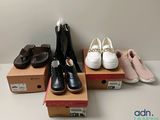 several pairs of women ' s shoes sitting on top of boxes on a table