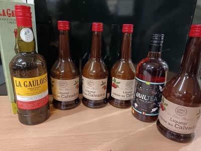 plusieurs bouteilles d'alcool posées sur une table à côté d'un livre
