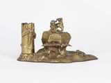 brass figurine of a man and woman sitting on a rock with a candle