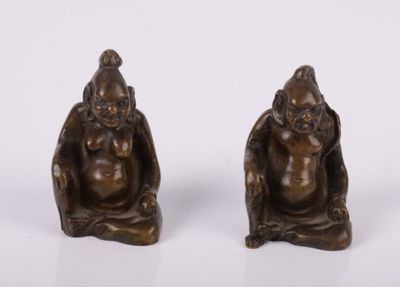 une paire de figurines en bronze représentant un homme et une femme assis à genoux