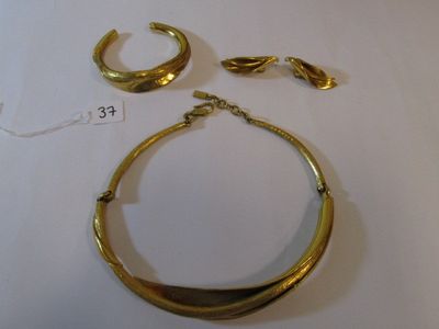 un collier en or et une paire de boucles d'oreilles posés sur une table