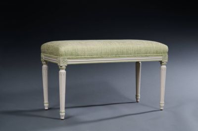 an upholstered bench with a green upholstered seat and legs