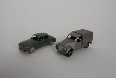 two toy cars sitting next to each other on a white surface