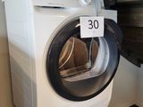 un lave-linge et un sèche-linge blancs dans une petite pièce