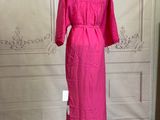 a pink dress on a mannequin stand in a room