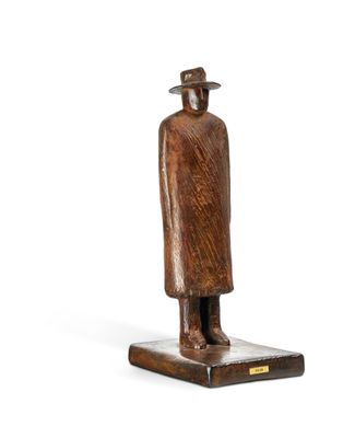 wooden statue of a man with a hat and coat on a wooden base