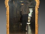 un homme debout devant un miroir dans une pièce