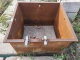 a rusted metal box with a chain around it