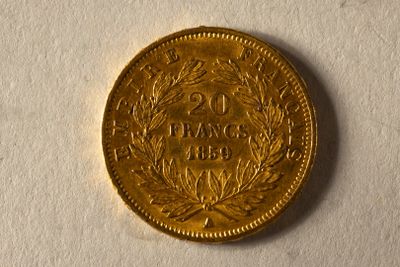 une pièce d'or ornée d'une couronne, posée sur un fond blanc