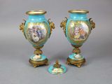 une paire de vases bleus et dorés ornés de portraits